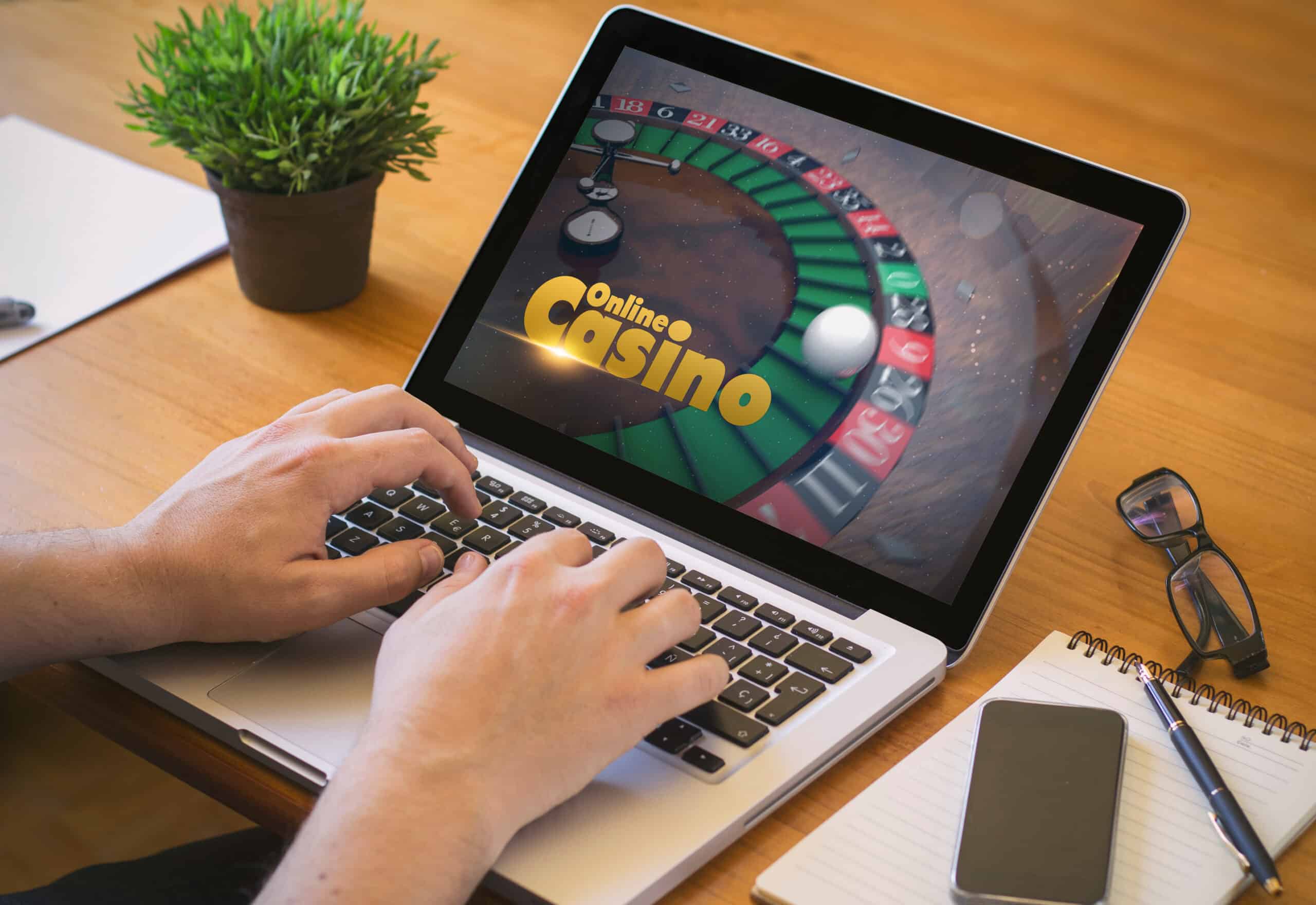 Persoană care folosește un laptop pe care apare un joc de cazinou online